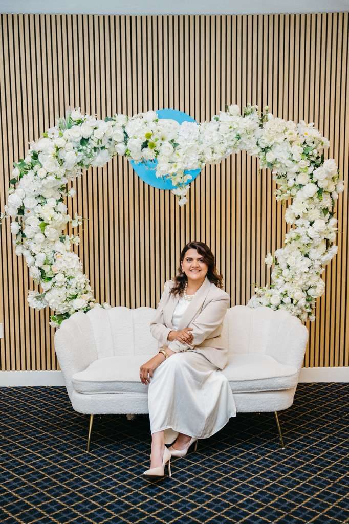Denise Sampaio sob o arco de flores